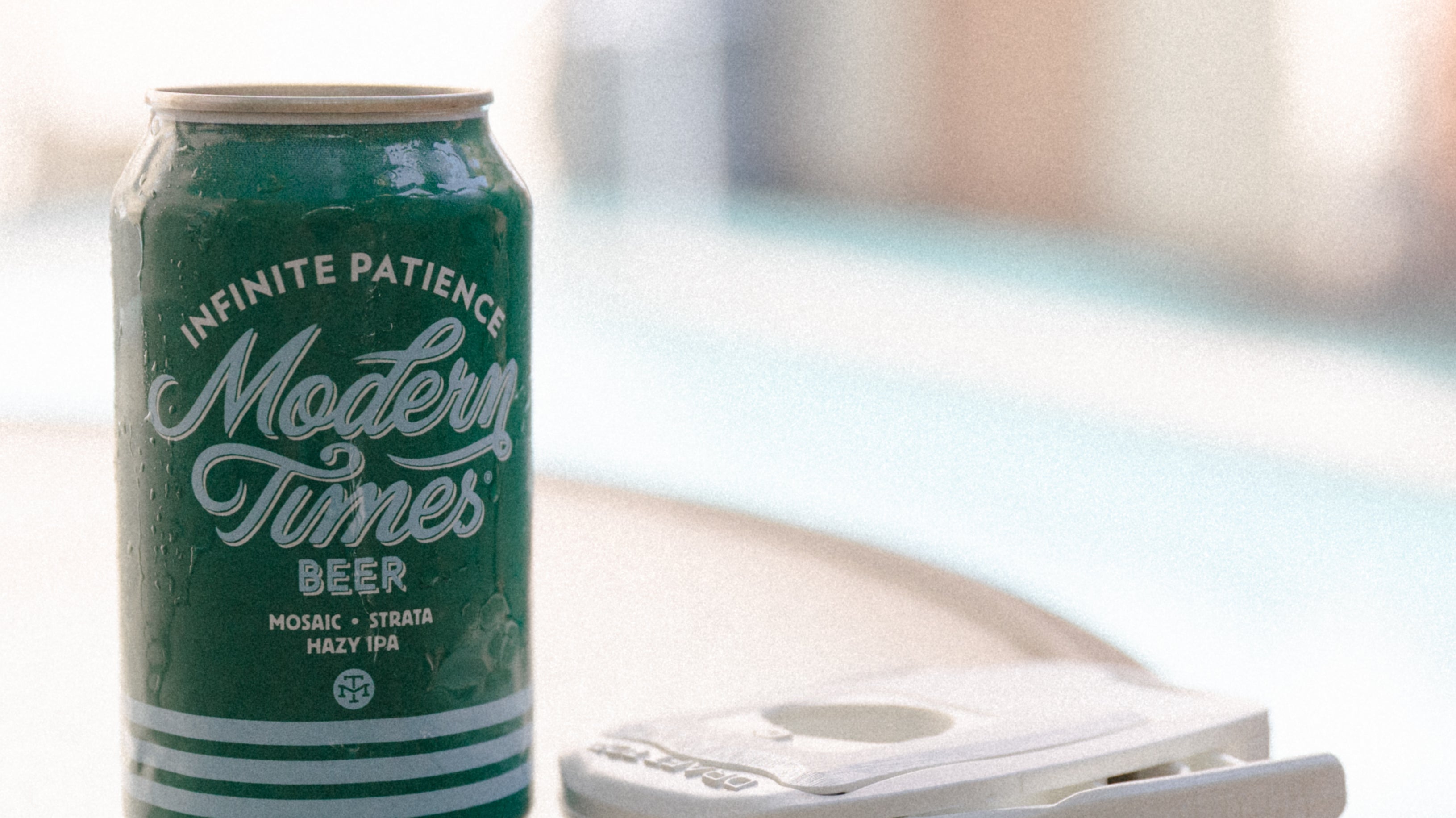 Beer next to Draft Top Lift on table next to pool